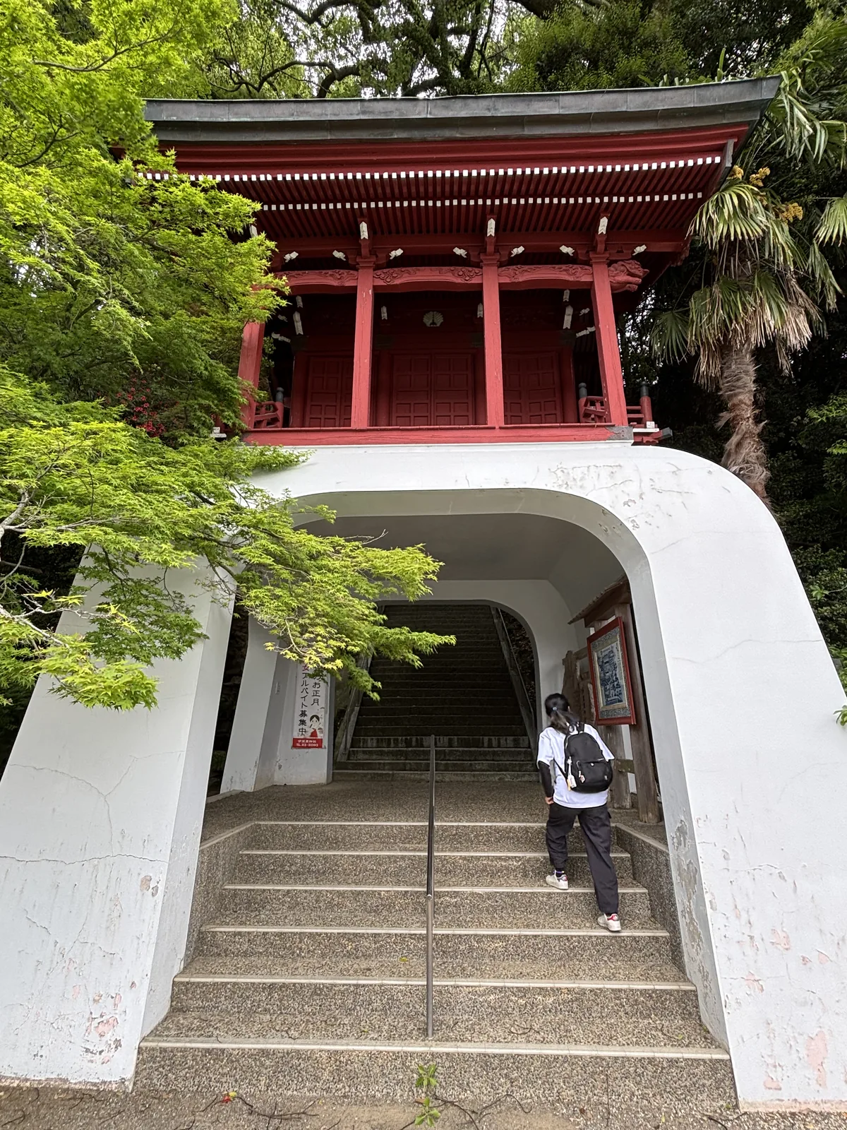 伊萬里神社的朱漆樓門，架在一座白色混凝土拱洞上，洞內是通往上方的石階