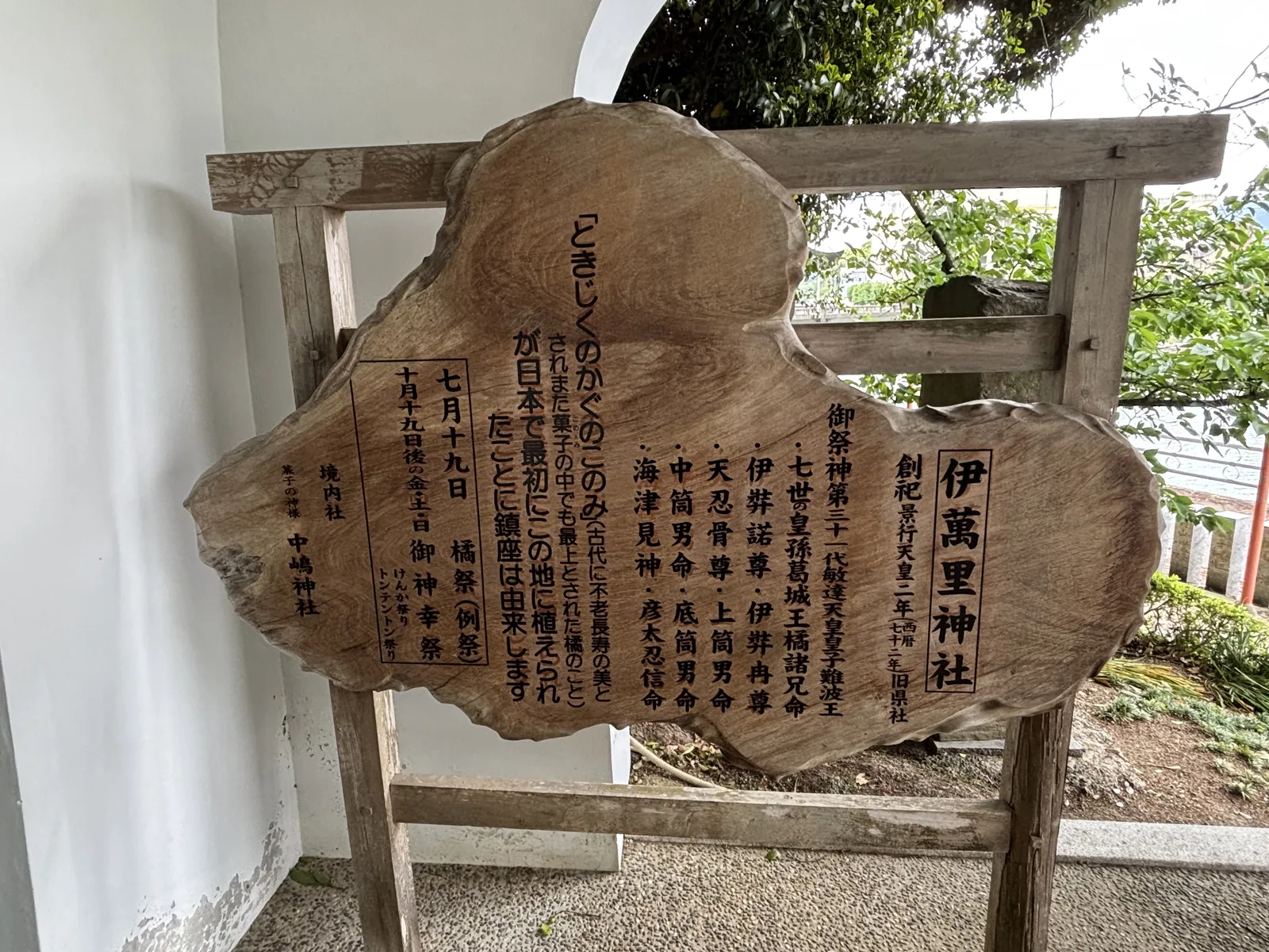 伊萬里神社的木製一枚板看板，直排刻字寫著創祀、御祭神與祭典