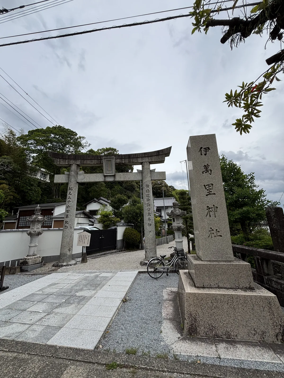 伊萬里神社的花崗岩社號標，刻著伊萬里神社四字，立在橋頭的路邊，右側是橋的欄杆