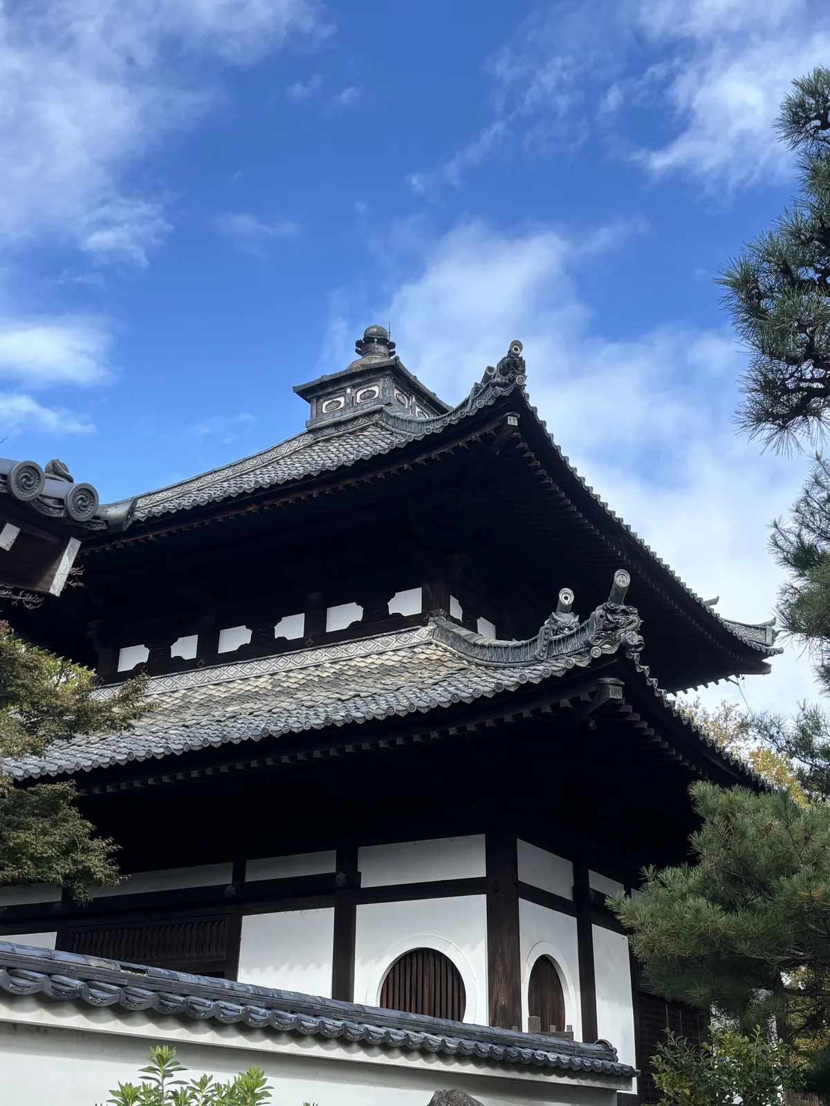東福寺庫裡的大唐破風：白色的妻壁上開著圓窗，屋頂的曲線一路壓到簷口，屋瓦是深色的本瓦