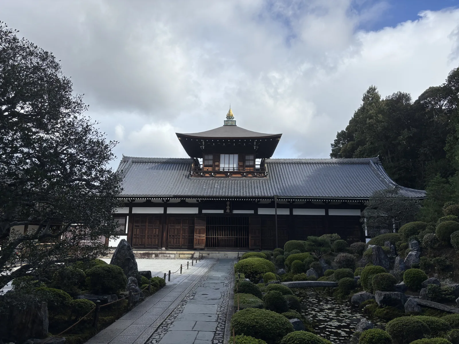 東福寺開山堂（常樂庵）：本瓦葺的堂宇立在坡上，屋頂中央另立一座小樓閣，那是傳衣閣，堂前是修剪過的植栽與白砂