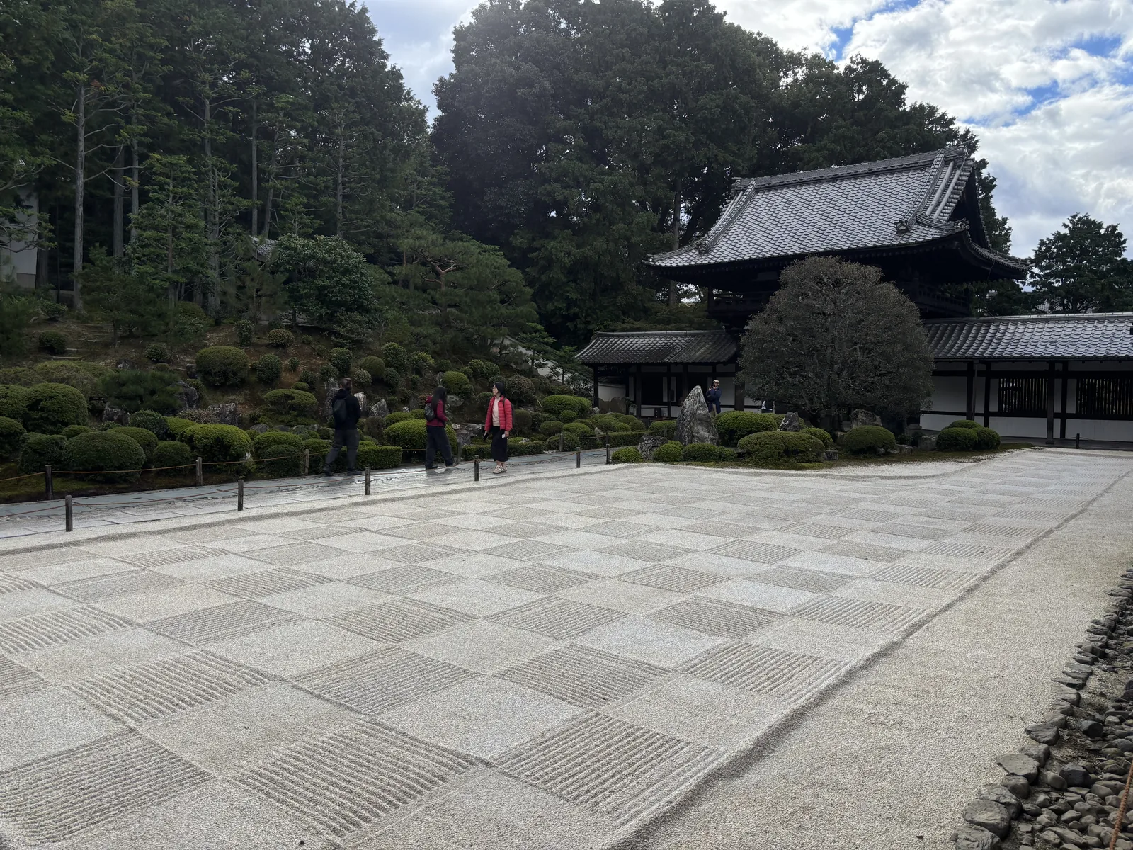東福寺開山堂前的白砂庭園：砂紋耙成整齊的市松格子，一格一格排到坡腳，坡上是開山堂與周圍的樹