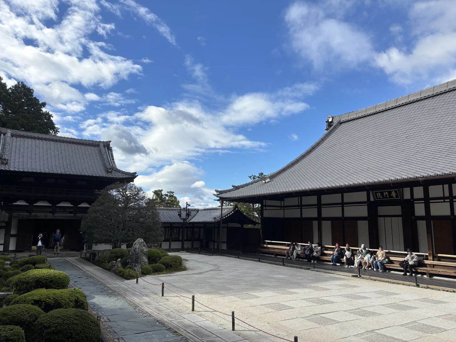 東福寺普門院的扁額：黑地金字寫著「普門院」，掛在深色的木構之間，上方是白色的本瓦屋頂