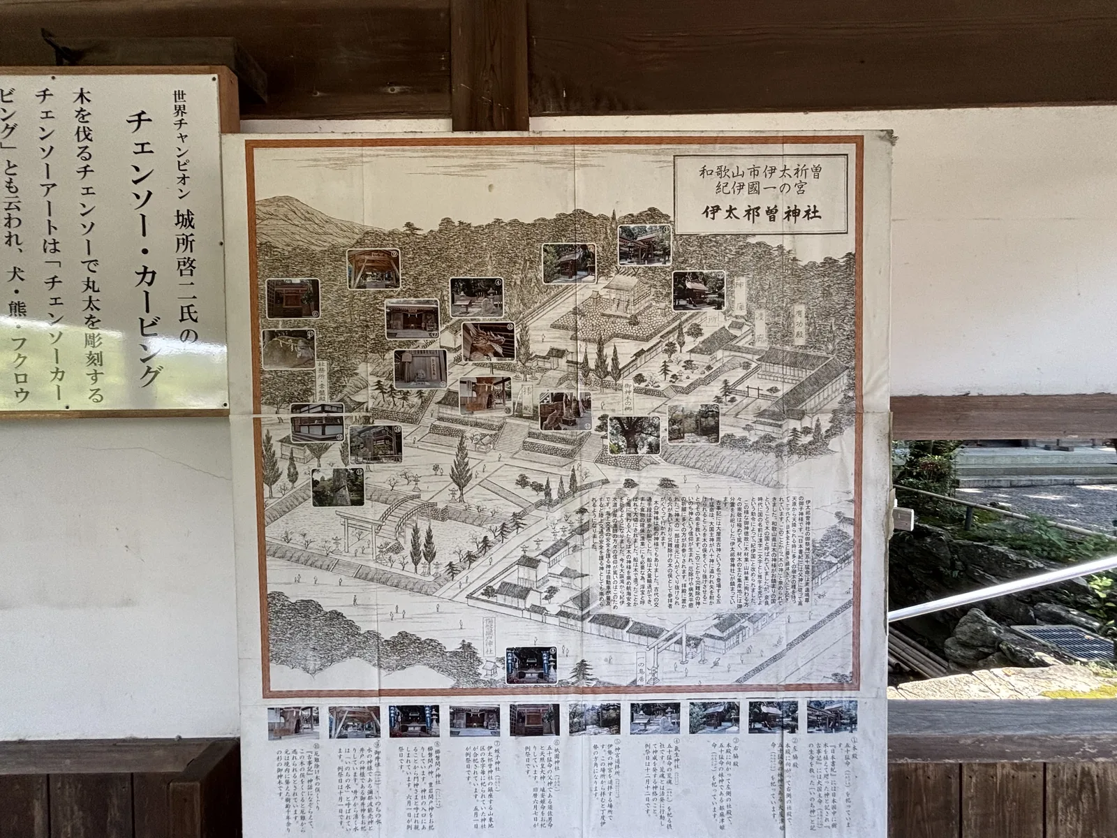 伊太祈曾神社境內牆上的兩件掲示：手繪鳥瞰的境內案內圖，以及介紹鏈鋸雕刻的白底木框說明「世界チャンピオン　城所啓二氏の　チェンソー・カービング」