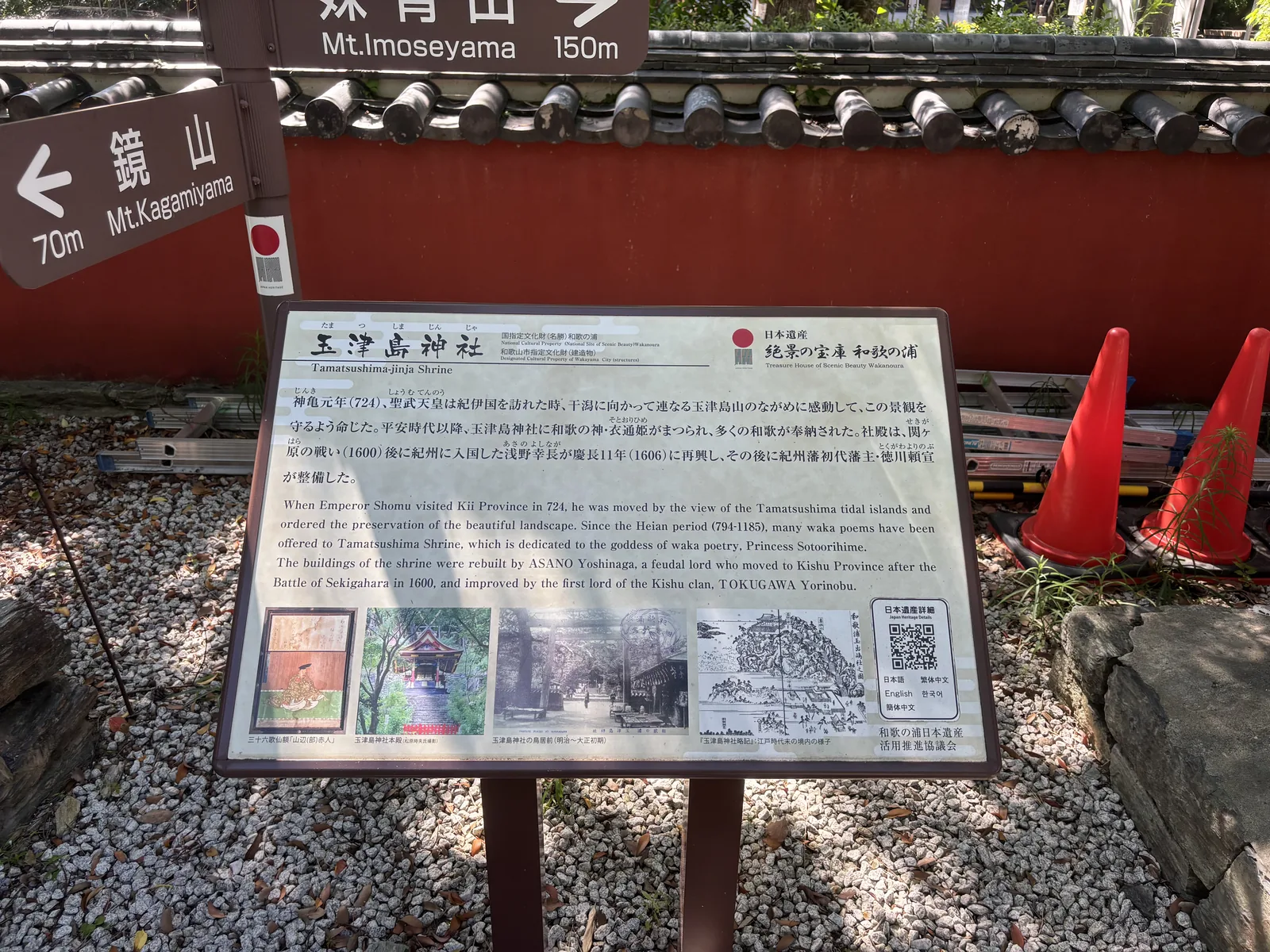標「國指定文化財（名勝）和歌の浦」與「和歌山市指定文化財（建造物）」。記神龜元年（724）聖武天皇行幸、感動於玉津島山的景觀而下令守護；社殿由淺野幸長於慶長十一年（1606）再興、其後德川賴宣整備。背後的赤壁上方，道路指標寫「鏡山 70 m／妹背山 150 m」。