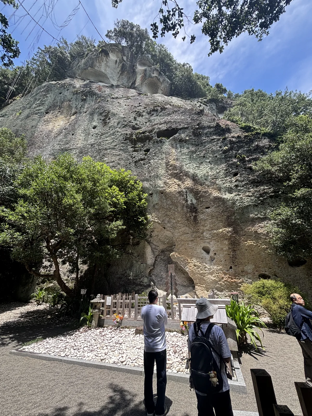 御神體。四十五公尺高的灰白岩壁，滿面圓形凹窩，底下鋪白石、圍木造玉垣為拜所。沒有社殿，也沒有任何建築擋在人與岩之間。