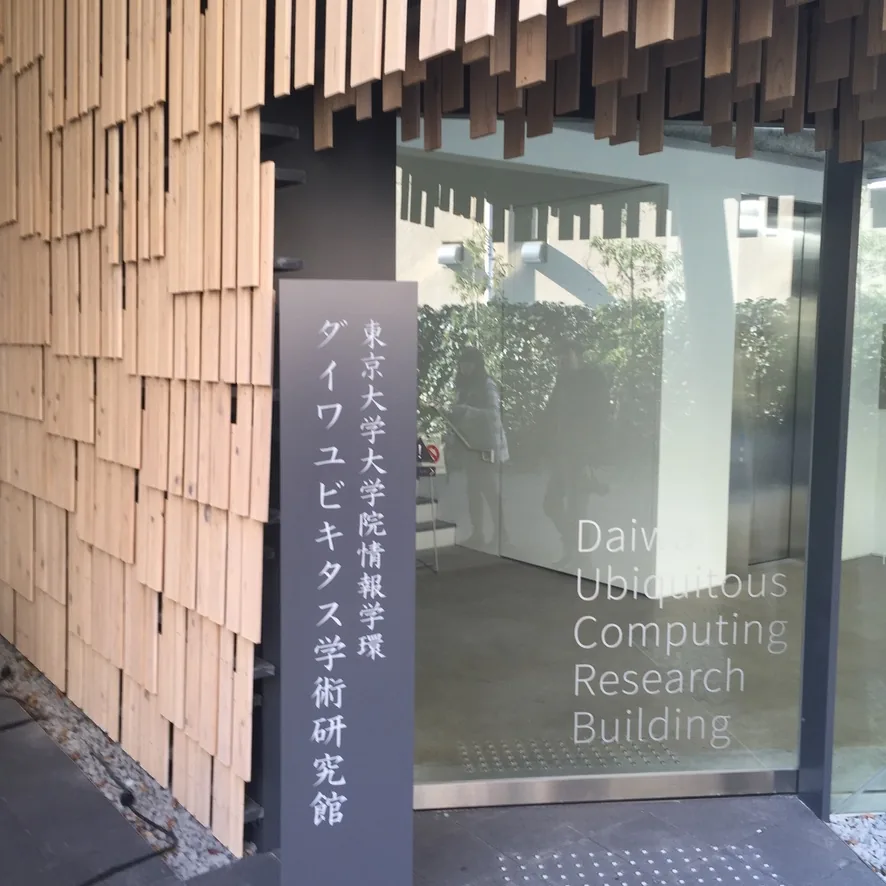 研究館的館名立牌，深灰色的立牌上以直書刻著館名，後方是玻璃入口與英文館名