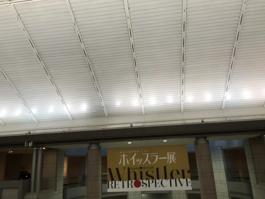 Grand Gallery 的屋頂，斜向的白色鋼構將玻璃屋頂分成數區，每一區以細密的白色 louver 覆蓋，下方是花崗石的柱列與展覽布幕