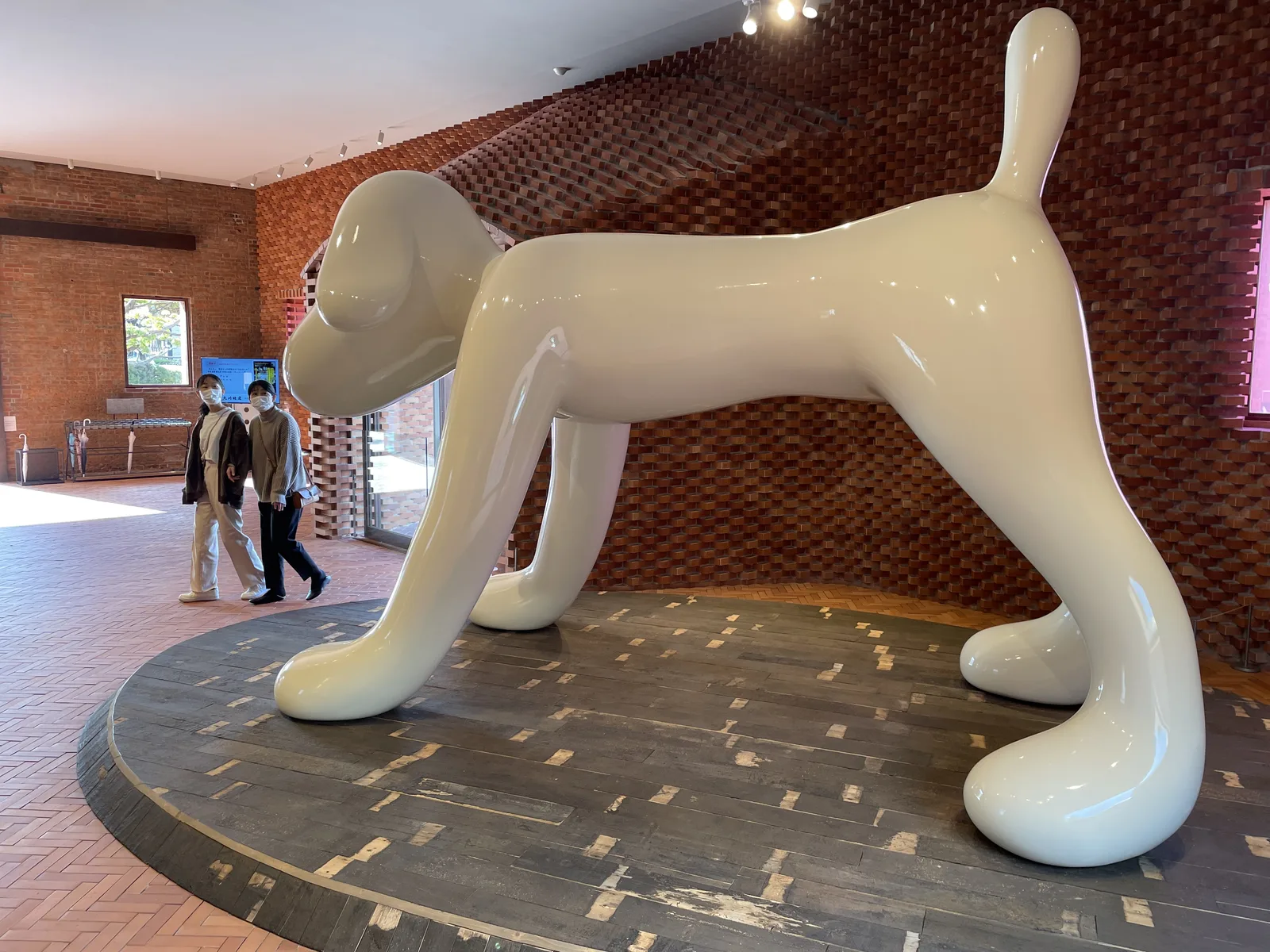《A to Z Memorial Dog》與後方的蛇腹式砌磚牆面