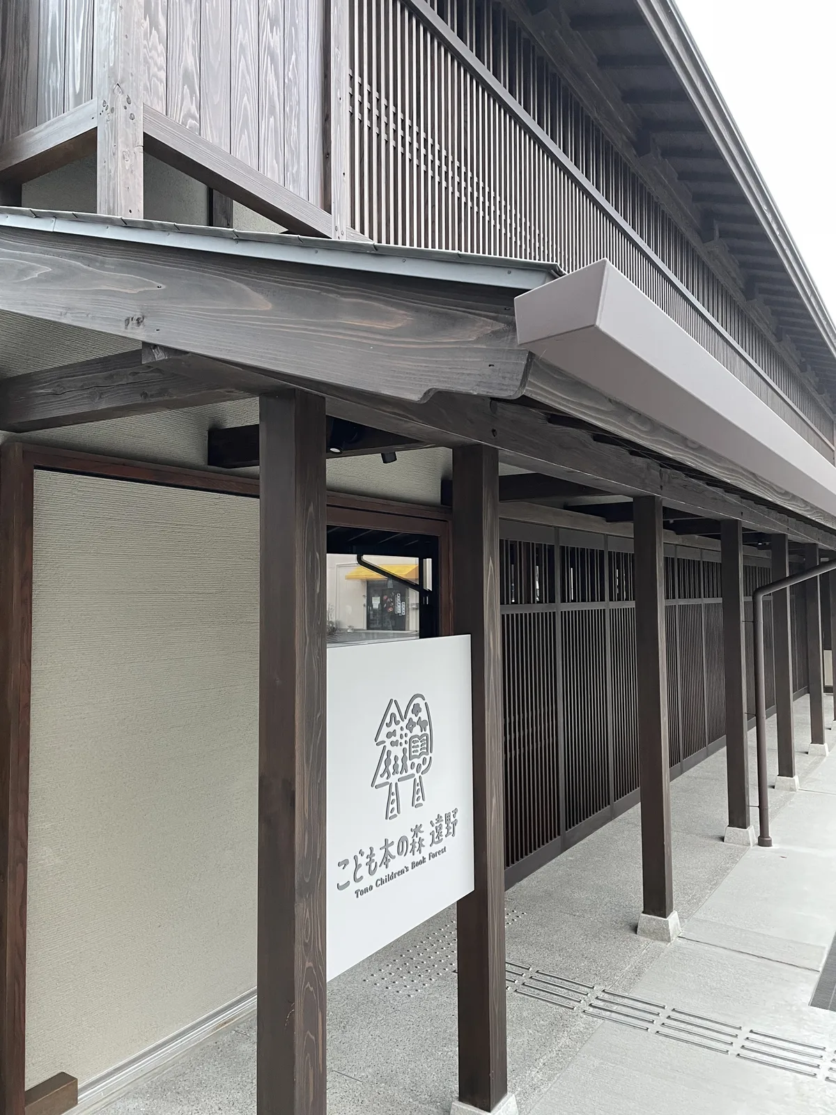 入口：深簷下的館名看板與木格子