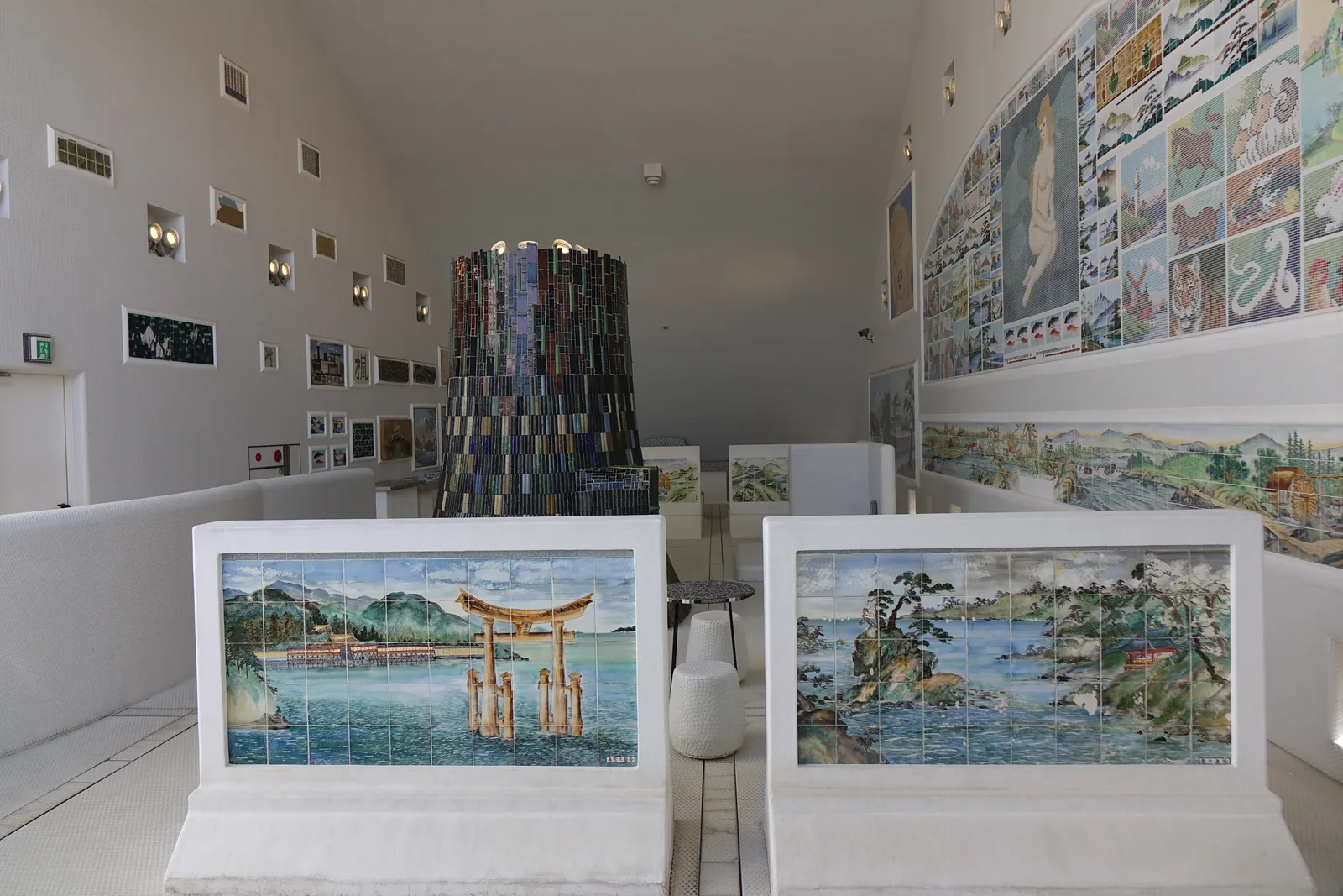 四樓展示室的另一側，白色的拱形牆面上嵌著大幅的風景磁磚畫與成列的小方窗，中央是黑色磁磚的塔狀物，前方的白色展示台上立著兩幅磁磚畫