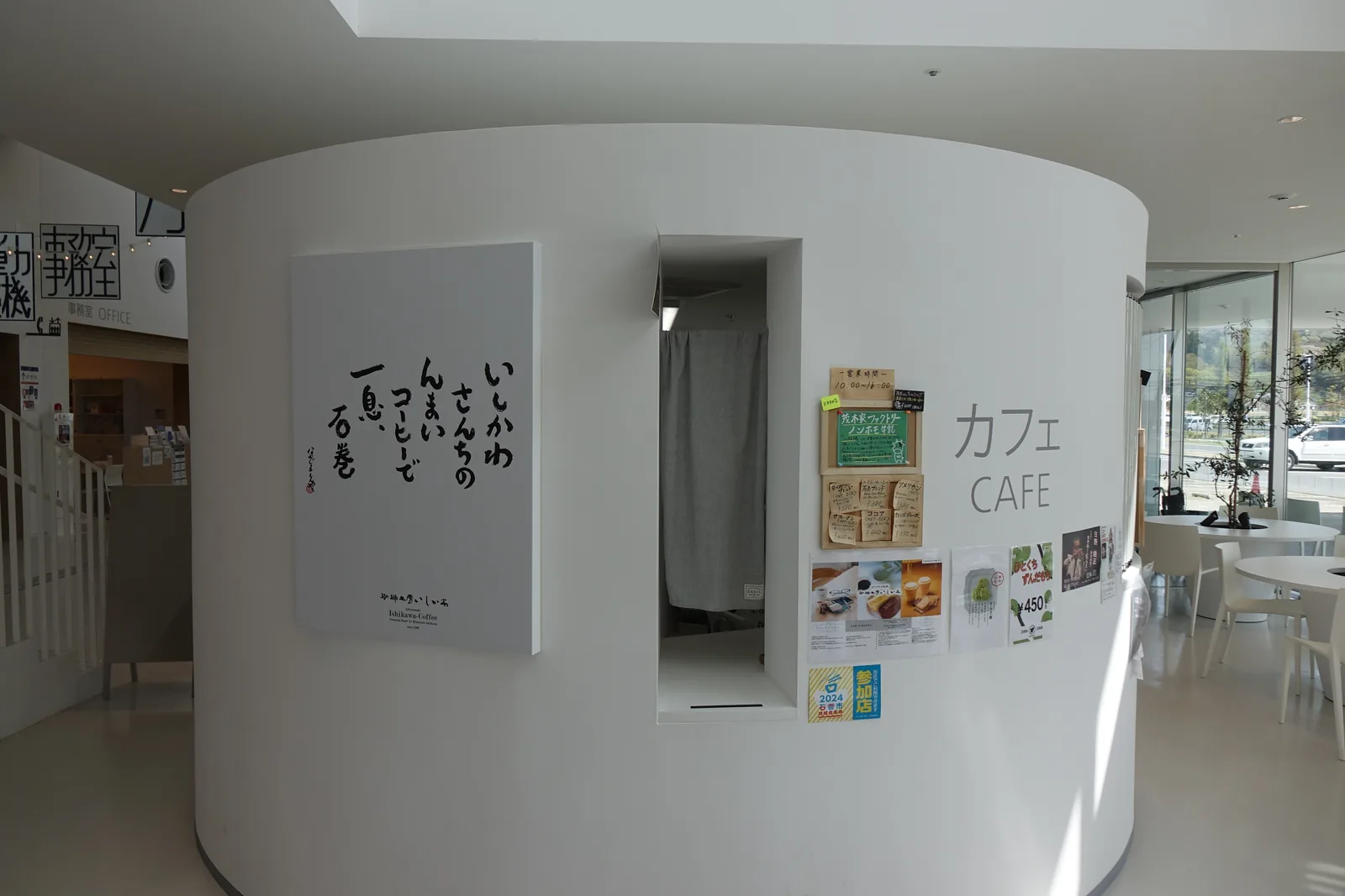 咖啡座弧形吧檯外側牆面，掛著「CAFE」標誌與手寫招牌