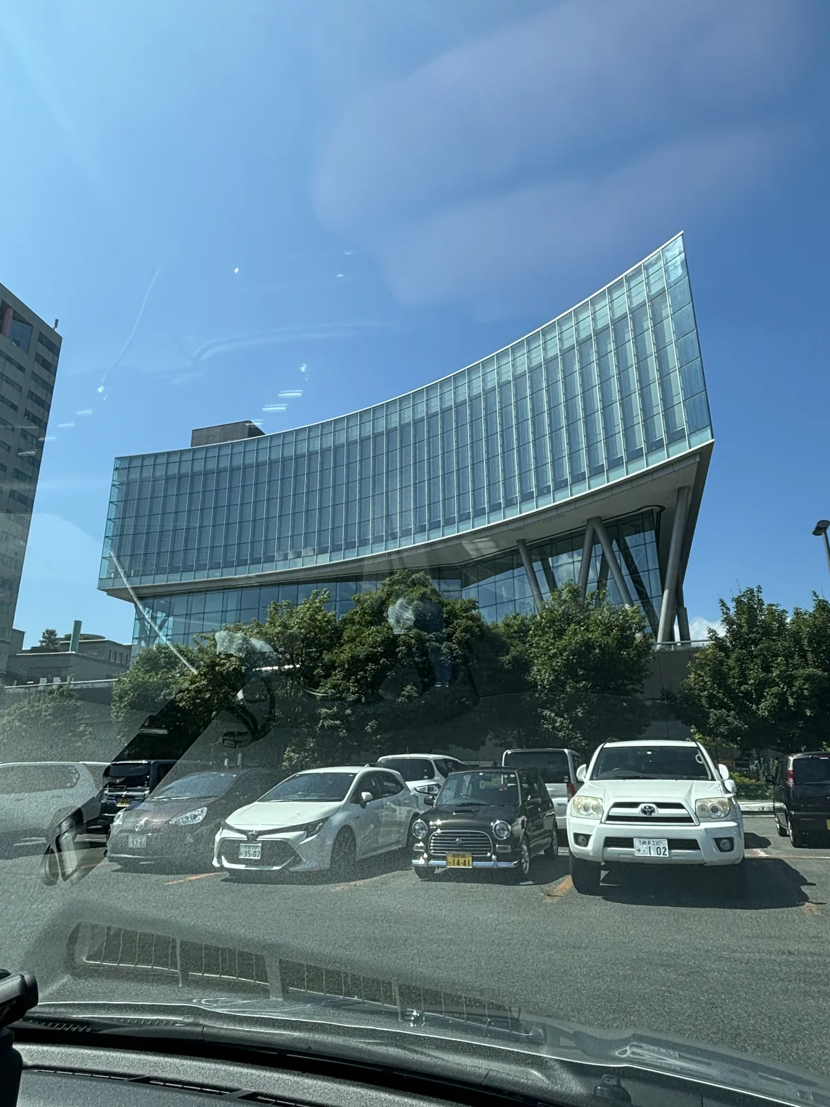 停車場回望外觀：上半部為外傾的弧形玻璃帷幕，由斜向鋼柱撐起