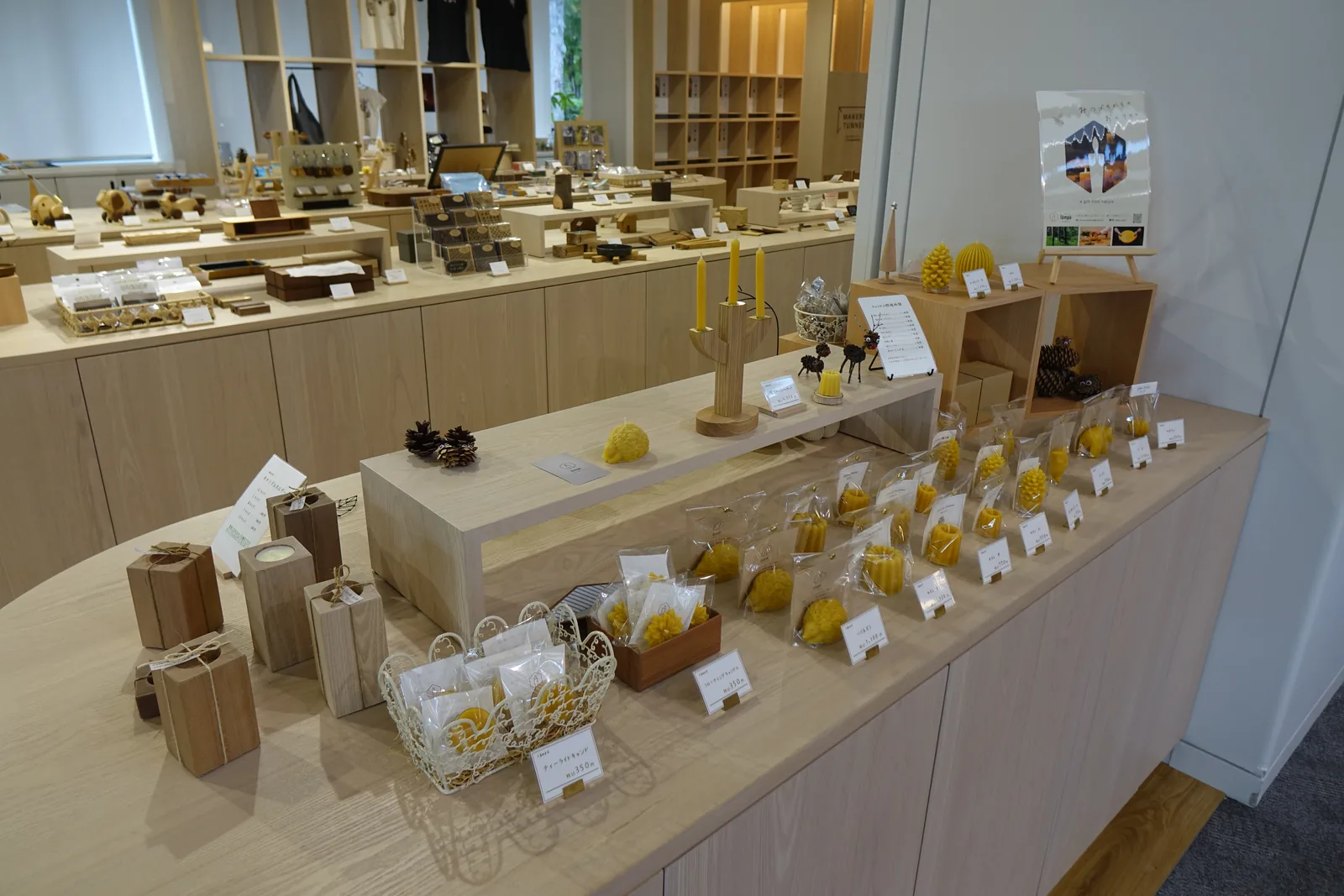 商店內的木作展示台與層架，陳列木製器物、蜜蠟燭與小型工藝品，後方為格狀木架