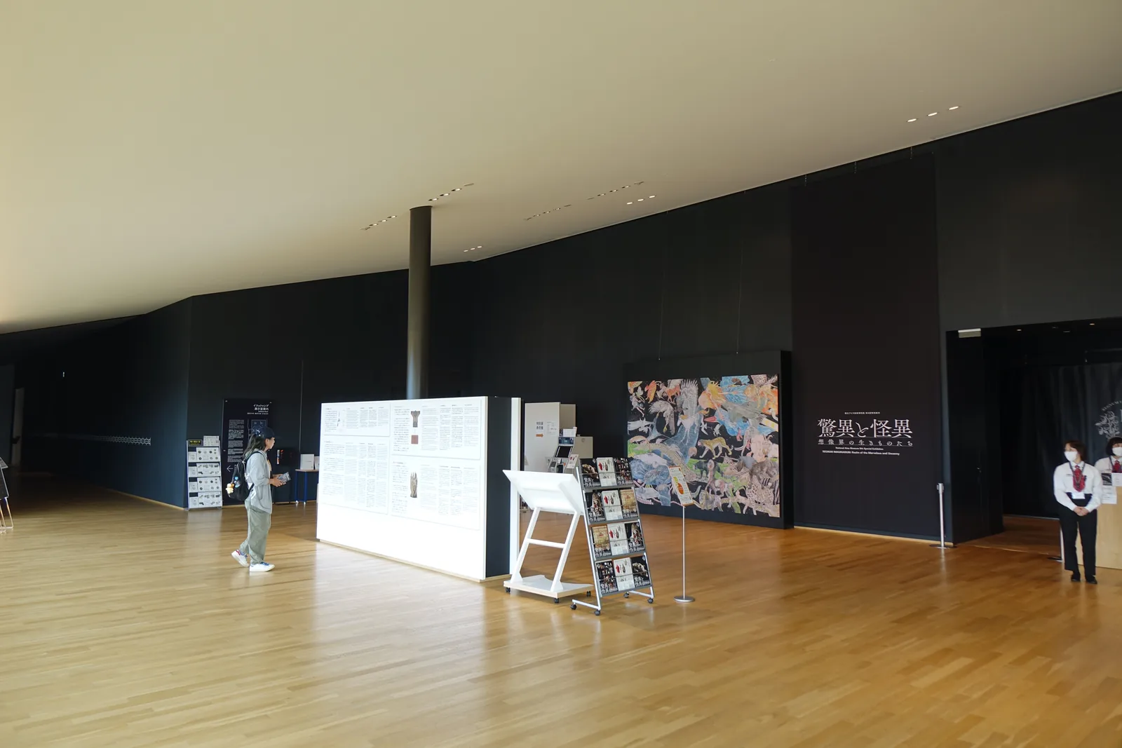 Panoramic Lobby 南側的展示室入口，深色牆面上為特別展的大幅海報，前方為白色的說明牆與手冊架，地面為木地板